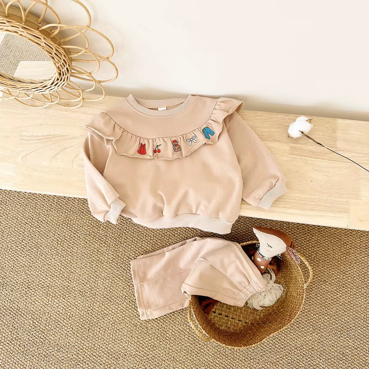 Children's beige outfit with ruffled collar.