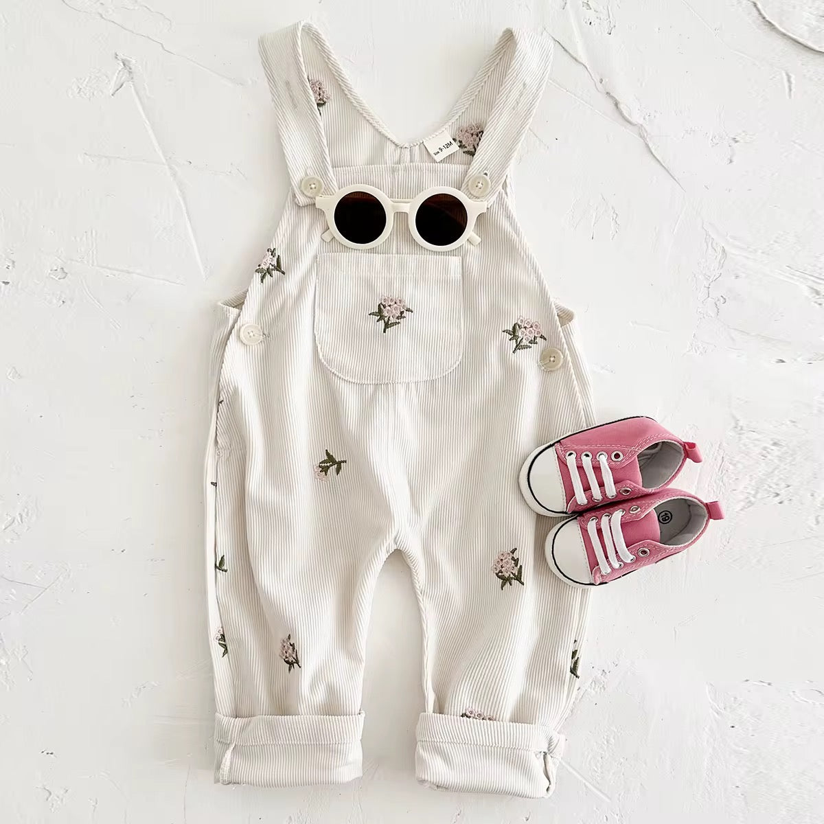 Embroidered floral baby overalls in soft cream corduroy front view